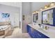 Double vanity bathroom with blue cabinets and a soaking tub at 351 N Cloverfield Cir, Litchfield Park, AZ 85340