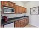 Compact kitchenette with wood cabinets and granite countertops at 351 N Cloverfield Cir, Litchfield Park, AZ 85340