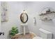Elegant powder room with pedestal sink, oval mirror, and decorative shelving at 351 N Cloverfield Cir, Litchfield Park, AZ 85340