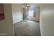 Bright bedroom with carpeted floors, a ceiling fan, and a large window at 5306 N 188Th Ln, Litchfield Park, AZ 85340