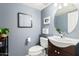 Small bathroom with dark vanity and oval mirror at 6872 W Linda Ln, Chandler, AZ 85226