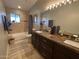 Modern bathroom with double vanity, granite countertop, and a bathtub at 8114 E Clarendon Ave, Scottsdale, AZ 85251