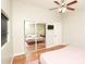 Bedroom with hardwood floors and mirrored closet featuring tree wall art at 8114 E Clarendon Ave, Scottsdale, AZ 85251