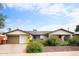 Attractive single-story home with a yellow door and well-maintained landscaping at 8114 E Clarendon Ave, Scottsdale, AZ 85251