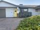 Updated mid-century home with yellow door and landscaping at 8114 E Clarendon Ave, Scottsdale, AZ 85251