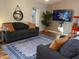 Living room with dark sofa and large TV at 8114 E Clarendon Ave, Scottsdale, AZ 85251