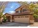 Two-story house with tan exterior, two-car garage, and landscaping at 835 E Marigold Pl, San Tan Valley, AZ 85143