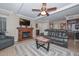 Living room with a fireplace, comfortable seating, and a large TV at 9902 W La Jolla Cir, Sun City, AZ 85351