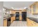 Modern kitchen with wood cabinets and black appliances at 1029 E Lodge Dr, Tempe, AZ 85283