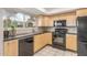 Modern kitchen with wood cabinets and black appliances at 1029 E Lodge Dr, Tempe, AZ 85283
