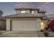 Two-story house with beige walls, a tile roof, and a two-car garage at 10760 W Monte Vista Rd, Avondale, AZ 85392