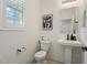 Clean powder room with pedestal sink, toilet, and modern art at 10994 W Mckinley St, Avondale, AZ 85323