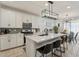 Modern kitchen with white cabinets, quartz island, and stainless steel appliances at 10994 W Mckinley St, Avondale, AZ 85323