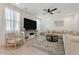Spacious living room with sectional sofa, large TV, and ceiling fan at 10994 W Mckinley St, Avondale, AZ 85323