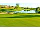 Lush green golf course with lake and trees at 11668 W Cholla Ct, Surprise, AZ 85378