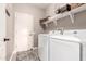 Convenient laundry room with washer, dryer, and shelving at 15253 W Pasadena Dr, Surprise, AZ 85374