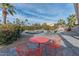 Relaxing patio area with orange chairs and table, overlooking the pool at 15538 W Whitton Ave, Goodyear, AZ 85395