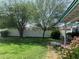 Backyard featuring a white fence, green grass, and mature trees providing ample shade at 2207 W Hayward Ave, Phoenix, AZ 85021