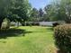 Lush backyard featuring mature trees, vibrant bushes, picnic table and white picket fence at 2207 W Hayward Ave, Phoenix, AZ 85021