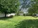 Expansive backyard featuring lush green grass, mature trees, and a classic white picket fence at 2207 W Hayward Ave, Phoenix, AZ 85021