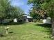 Spacious backyard showcasing lush green lawn, mature trees, and a white privacy fence at 2207 W Hayward Ave, Phoenix, AZ 85021