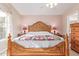 Ornate wooden bed frame in a spacious bedroom with a window and neutral walls at 2207 W Hayward Ave, Phoenix, AZ 85021
