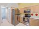 Kitchen with stainless steel appliances and wood cabinetry at 2207 W Hayward Ave, Phoenix, AZ 85021