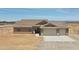 Single-story home with desert landscaping, neutral toned exterior, and a three-car garage in a fenced lot at 22270 W Skinner Rd, Wittmann, AZ 85361