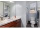 Well-lit bathroom with a vanity, modern sink, and a glass-enclosed shower and lavatory at 30704 N 138Th Ave, Peoria, AZ 85383