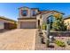 Charming two-story home featuring a desert landscape, a brick driveway, and a two-car garage at 30704 N 138Th Ave, Peoria, AZ 85383