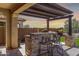 Inviting outdoor kitchen with a built-in grill and bar, perfect for entertaining and enjoying meals outdoors at 30704 N 138Th Ave, Peoria, AZ 85383
