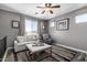 A cozy sitting room with a ceiling fan, neutral colors, and a comfortable couch at 30704 N 138Th Ave, Peoria, AZ 85383