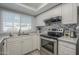White kitchen cabinets, gray countertops, and stainless steel appliances at 4102 E Blanche Dr, Phoenix, AZ 85032