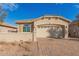 Tan single-story house with a two-car garage and a brick driveway at 4124 W Palace Station Rd, New River, AZ 85087