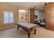 Game room with pool table and barn doors opening to a sitting area at 41717 N Harbour Town Way, Anthem, AZ 85086