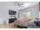 Large bedroom with large TV, ceiling fan, and dresser at 44783 W Alamendras St, Maricopa, AZ 85139