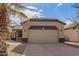 Tan house with a two-car garage and palm trees at 44783 W Alamendras St, Maricopa, AZ 85139