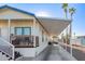 Single-wide manufactured home with carport, steps, and covered porch at 5201 W Camelback Rd # F316, Phoenix, AZ 85031