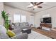 Bright living room features a comfy couch, large TV, and ceiling fan at 5201 W Camelback Rd # F316, Phoenix, AZ 85031
