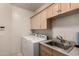 Laundry room with washer, dryer, and utility sink at 7942 E Sugarloaf Cir, Mesa, AZ 85207