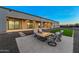 Cozy backyard setup with a modern fireplace surrounded by comfortable chairs, set against a backdrop of a well-manicured lawn at 8110 E Saddle Horn Rd, Scottsdale, AZ 85255
