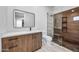 Stylish bathroom boasts wood grain vanity with white countertop and frameless glass shower doors at 8110 E Saddle Horn Rd, Scottsdale, AZ 85255