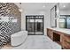 Bright bathroom featuring a freestanding tub, a decorative wall, dual sinks, vanity, and walk-in shower with marble floors at 8110 E Saddle Horn Rd, Scottsdale, AZ 85255