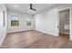 Bright bedroom with wood floors, two windows, and ceiling fan, leading into large closet space at 8110 E Saddle Horn Rd, Scottsdale, AZ 85255