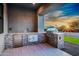 Covered outdoor kitchen features a built-in grill, mini fridge, and stone accents at 8110 E Saddle Horn Rd, Scottsdale, AZ 85255