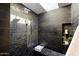 Spa-like shower with dark tile, skylight, and built-in shelving at 8521 N 15Th Dr, Phoenix, AZ 85021