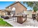 Outdoor kitchen with built-in grill, bar seating, and adjacent patio at 9230 E Fairfield St, Mesa, AZ 85207