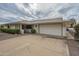 Front view of a ranch-style home with a two-car garage and neat landscaping at 10027 W Concord Ave, Sun City, AZ 85351