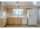 Bright kitchen with white appliances and light wood cabinets at 10027 W Concord Ave, Sun City, AZ 85351