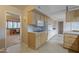 Kitchen with light wood cabinets, microwave, and view into living room at 10027 W Concord Ave, Sun City, AZ 85351